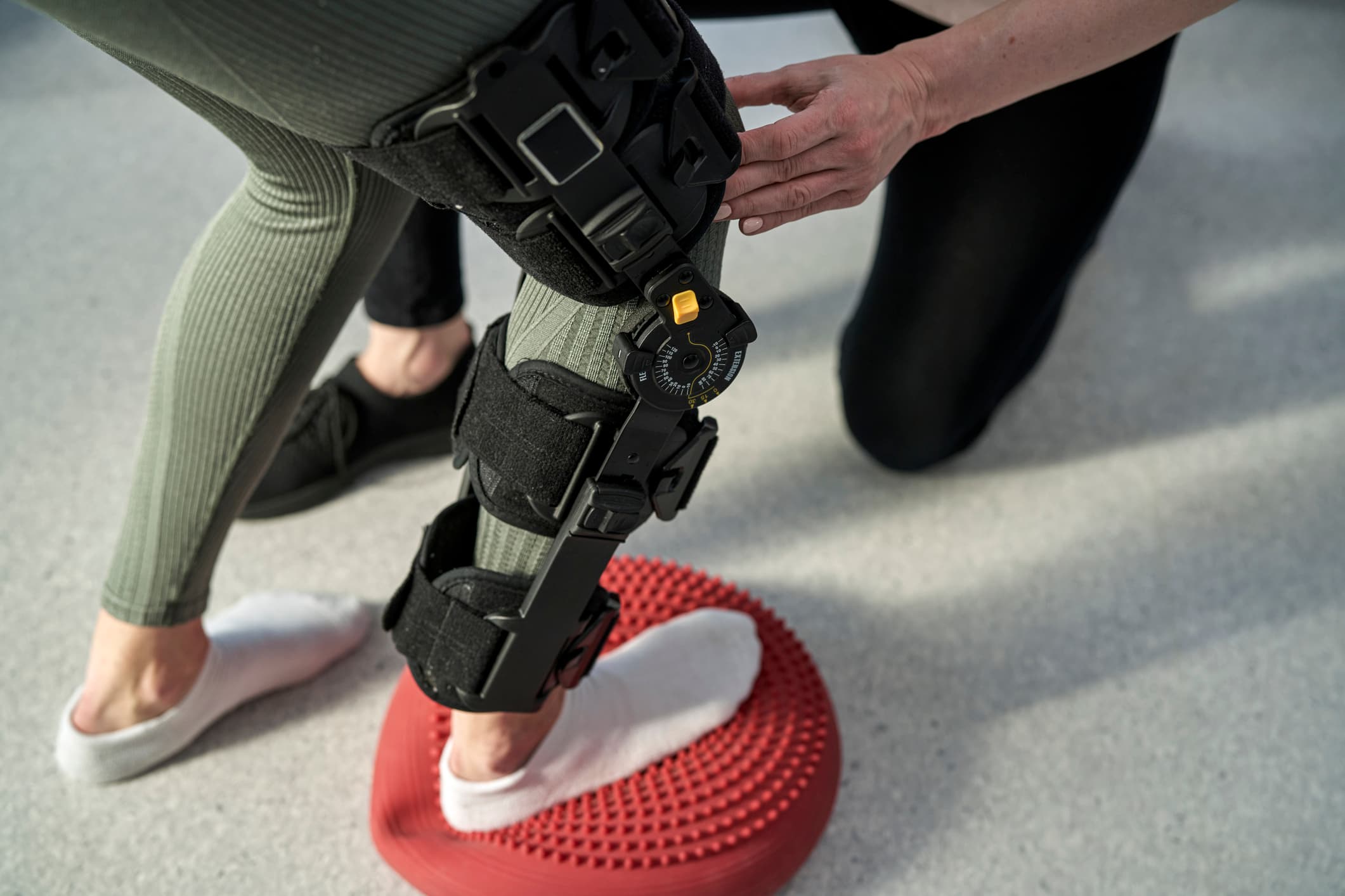 revaliderende patient na knieoperatie in kniebrace op stabiliteitskussen